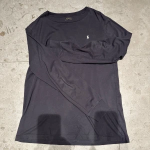 Svart långärmad tröja från Polo Ralph Lauren - Säljer en stilren svart långärmad tröja från Polo Ralph Lauren. Tröjan har en liten broderad logotyp på bröstet och är tillverkad i mjukt material för extra komfort. Perfekt för en avslappnad look.