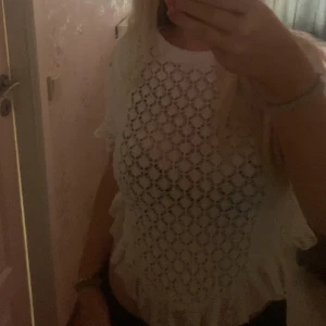 Vit spetsblus - Säljer en söt vit spetsblus med korta ärmar och volangdetaljer. Perfekt för en somrig look. Blusen har ett vackert mönster och är lätt och luftig. den är köpt för länge sen men är aldrig använd pris går att diskutera