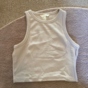 Beige topp - Snygg beige ribbad linnetopp från H&M. Perfekt för varma dagar med sin ärmlösa design och croppad längd. Enkel och stilren, passar till det mesta i garderoben.😻Perfekt basplagg att ha och super skön❤️