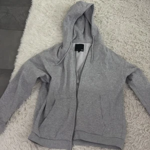 Grå huvtröja med dragkedja - Säljer en grå huvtröja med dragkedja. Tröjan har långa ärmar och en bekväm passform. Perfekt för en avslappnad stil. 🩶