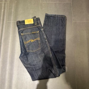 Nudie Jeans - Nudie Jeans av modellen  Slim Jim Storlek: 32/34 - Skicket på jeansen är mycket bra - 10/10 - mitt pris: 499- Nypris: 1599kr.   OBS den har en liten slitning vid foten längst ned men inget som verkligen syns när de är väll  på . Men En stor fördel med Nudies jeans jämfört mot eevis, Tiger of Sweden, Replay, Lee, Acne, dondup osv. Är att du kan lämna in dem gratis for reparation eller uppläggning i Stockholm, Göteborg eller Malmö. Pa sả vis förlängs livslängden rejalt.