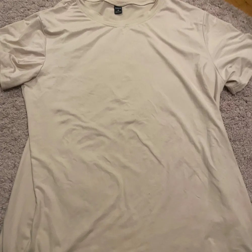 Säljer en enkel och stilren beige t-shirt från SHEIN. T-shirten har en normal passform och korta ärmar, perfekt för en avslappnad look. Tillverkad i ett mjukt material som känns skönt mot huden.. T-paidat.
