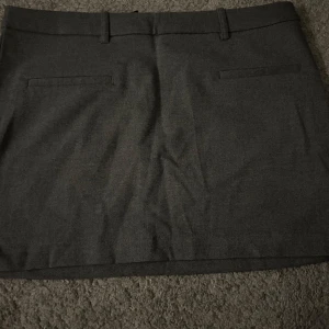 Svart kortkjol med bälteshällor - Snygg svart kortkjol med bälteshällor och diskreta fickor. Perfekt för en stilren look. Använd 1 gång❤️