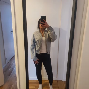 Grå jacka - Snygg grå sweatshirt jacka med dragkedja framtill. Jackan har en klassisk design med ribbade muddar vid ärmslut och nederkant. Perfekt för en casual look. Stl S