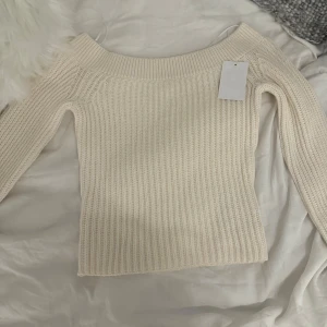 tröja från H&M - Säljer tröja från H&M. Tröjan har en offshoulder-design och långa ärmar.🩷med prislapp kvar. Skulle säga ett mellan ting mellan vit och beige 