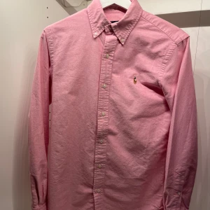 Rosa skjorta från Ralph Lauren - 🌟 Ralph Lauren Skjorta | Skick 9,5/10 knappt använd | Rosa | Xs på lappen men sitter som en S | Givetvis äkta | 1500kr nypris | Fraktar spårbart via PostNord eller instabox | Hör av dig vid frågor eller andra funderingar! 🌟