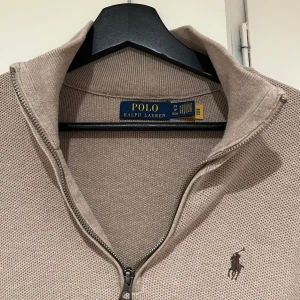 Beige tröja från Ralph Lauren - Tjena, säljer en stilren beige tröja från Ralph Lauren med dragkedja och broderad logga på bröstet. Halvzip. Nypris: 2200kr
