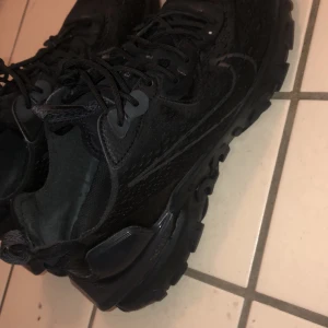 Svarta Nike React Vision - Snygga och moderna svarta Nike React Vision sneakers med en stilren design. Skorna har en bekväm sula och snörning för optimal passform. Perfekta för både vardag och träning. Helt nya har använt ett par gånger verkligen fina och nya skor 