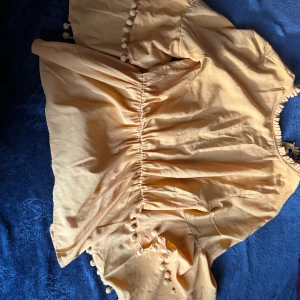 Gul blusa med gula  bomullsbollar - Jätte skönt och bra material  har använt en gång 