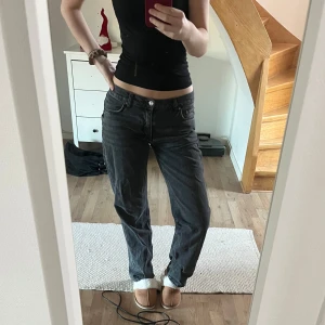Svarta lågmidjade jeans  - Säljer ett par svarta jeans med en avslappnad passform. Byxorna har en låg midja och klassisk femficksdesign. Perfekta för en casual look.