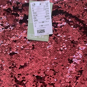 Röd paljettkjol - Snygg röd kjol täckt med glittrande paljetter. Perfekt för att sticka ut på festen. Kjolen har en kort längd och en figurnära passform.