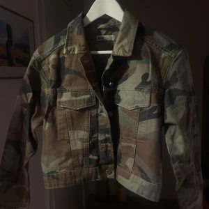 Camouflage jeansjacka  - Snygg camouflage jeans jacka  från Gina tricot. Jackan har en klassisk krage och knappar framtill. Perfekt för en cool och avslappnad stil.  