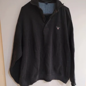 Svart långärmad tröja från Gant - Säljer en stilren svart långärmad tröja från Gant med krage och diskret logga på bröstet. Perfekt för en avslappnad men ändå snygg look. Passar bra till både jeans och chinos. Tröjan är i nyskick, bara använd få tal gånger. Köpte den för 2 månader sen.