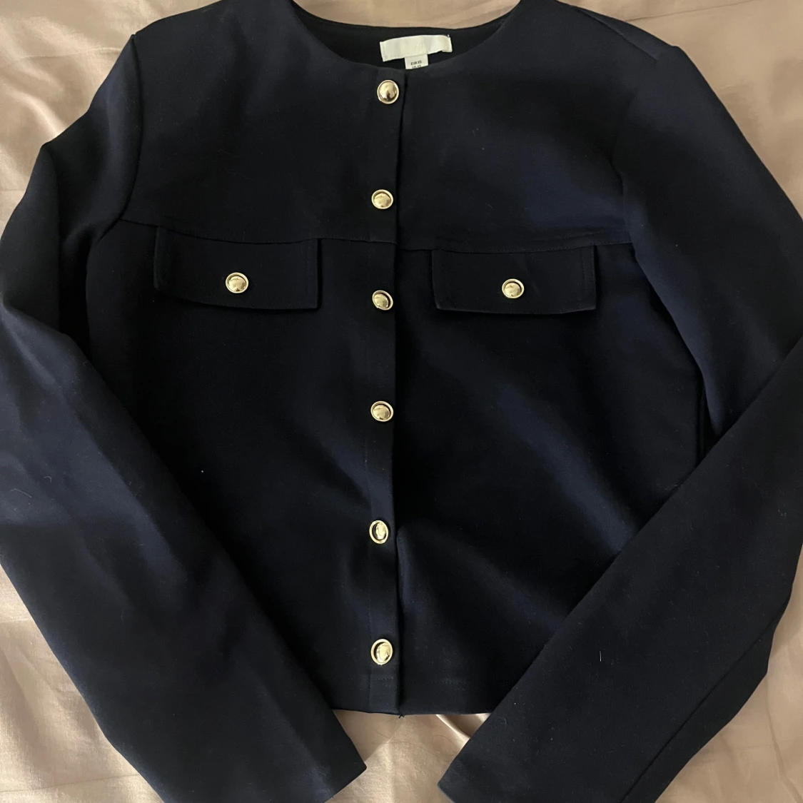 Marinblå kofta med guldknappar