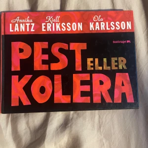 Pest eller Kolera - Säljer boken 'Pest eller Kolera' av Annika Lantz, Kjell Eriksson och Ola Karlsson. Den har en färgglad framsida med stora bokstäver i rött och guld. Boken handlar om att göra svåra val i livet med humor och insikt. Perfekt för dig som gillar att fundera över livets dilemman med en komisk twist.