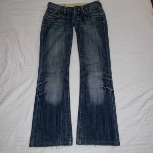 Lågmidjade jeans/low waist bootcut jeans - Såå snygga mörkblå, lågmidjade utsvängda jeans med snygga detaljer. Några få defekter men ingen man tänker på (se bilder), måtten finns också bland bilderna💕