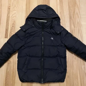 Vinterjacka  - Vinterjacka från Calvin Klein. Mycket fint skick men säljes billigt pga att den ej används. Storlek S. Jätte litet hål i ärmen.