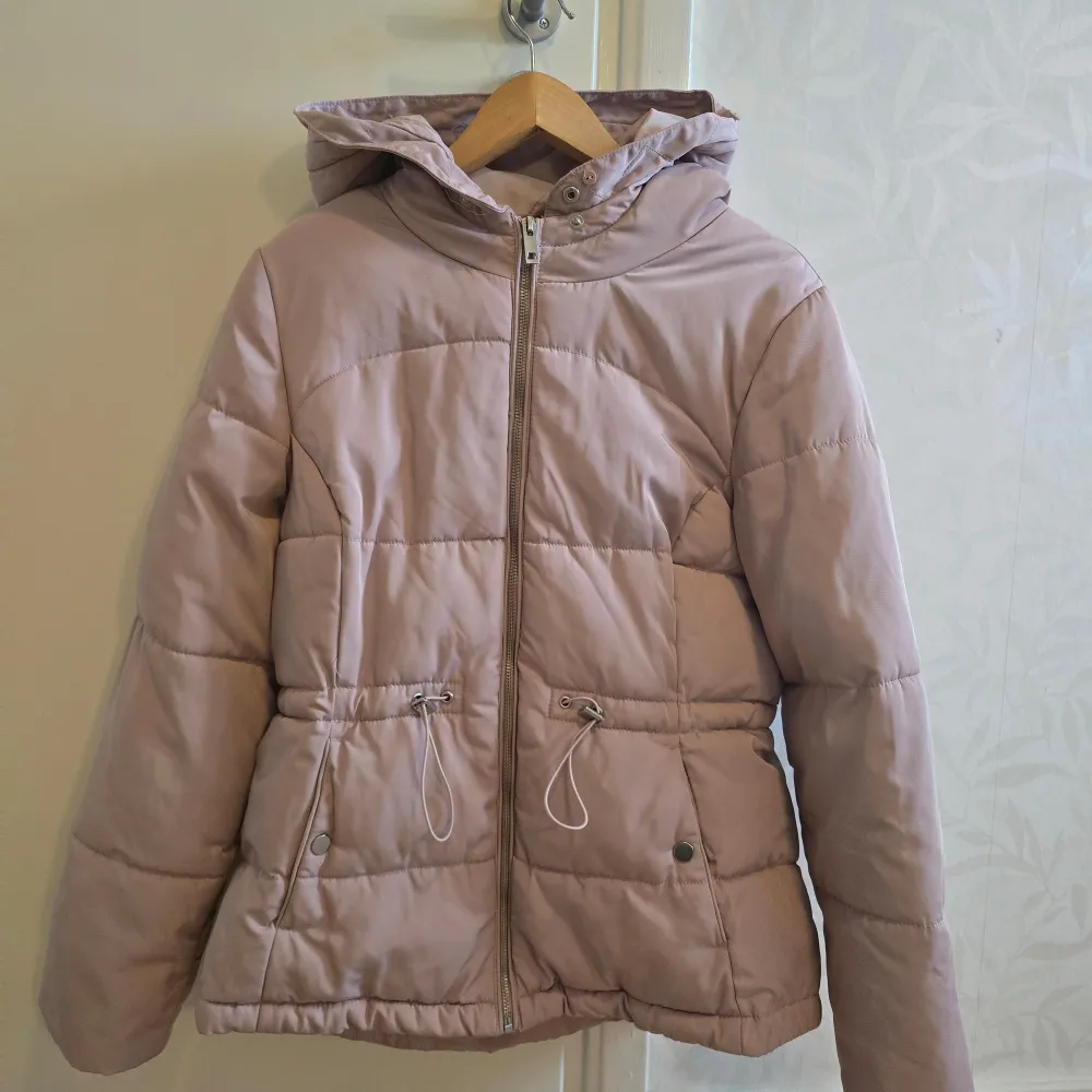 Säljer en superfin ljusrosa pufferjacka från H&M i storlek M. Jackan har en mysig huva och praktisk dragkedja framtill. Perfekt för kyliga höst- och vinterdagar. Den är i mycket bra skick och har justerbara snören i midjan för en bättre passform. 🧥✨. Takit.
