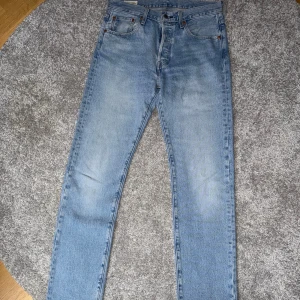 Levi’s 501 Ljusblå Straight Leg - Snygga jeans från Levi's i en ljusblå färg. De har en klassisk 501-modell med rak ben och en normal passform.  Storlek: 29 / 32  Nypris: 1149kr  Super fint skick!  Hör av dig vid fler frågor!
