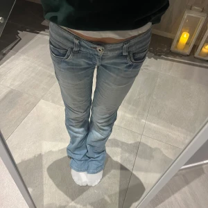 Lågmidjade bootcut jeans - Säljer ett par ljusblå lågmidjade bootcut jeans i bra skick. De är lågmidjade och har en klassisk femficksdesign med knapp och dragkedja fram. Innerbenslängd: ca 80cm, midjemått: ca 38cm❤️❤️🥹🥹