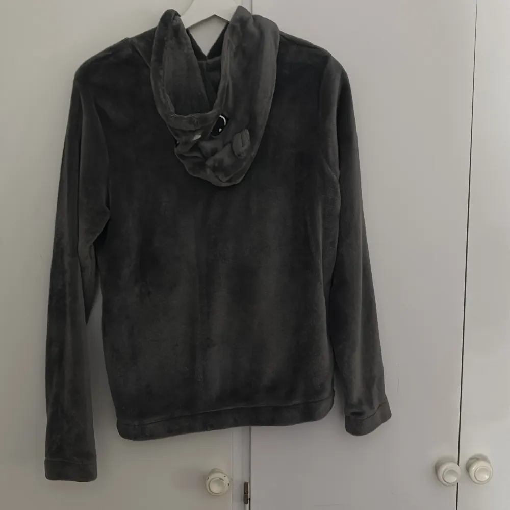 Mysig grå hoodie från H&M med texten 'WKEND mood' på framsidan. Den har en söt huva med kattansikte och öron, perfekt för en avslappnad helglook. Materialet är supermjukt och bekvämt, perfekt för kyliga dagar. 🐱. Tröjor & Koftor.