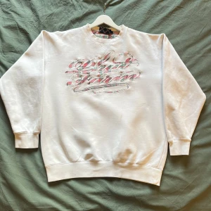 Vit Phat Farm Sweatshirt - Vit sweatshirt med grönt och rött broderi från Phat Farm. Bra skick (se en liten fläck och reva på sista bilden). Oversized med snygg 90-talig passform. 80% bomull & 20% polyester. Jag på bilden är ca S och 175cm lång. 