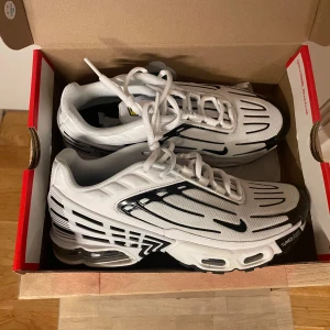 Nike air Max plus 3 GS - Ett par Nike skor som är använda fåtal gånger och är i väldigt bra skick!   Vita/svarta-chile red färg. Unisex.    Köpta för 1699kr men säljer de för 1000kr pga förlorat kvitto.    Mer bilder skickas vid intresse!  