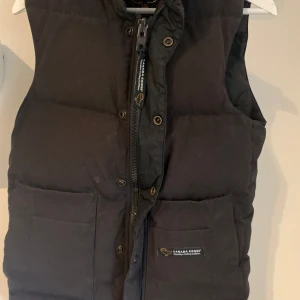 Canada Goose Väst - Svart Canada Goose väst i storlek XXS, men passar även XS. Tveka inte på att skriva om ni har några frågor!