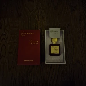 Maison Francis Kurkdjian Baccarat Rouge 540 Extrait de Parfum - Säljer en lyxig flaska av Maison Francis Kurkdjian Baccarat Rouge 540 Extrait de Parfum. Flaskan är elegant med en djup röd färg och en stilren guldig kork. Parfymen kommer i sin originalförpackning som också är röd med gyllene text. Perfekt för den som vill ha en exklusiv doftupplevelse. Den har sprejats några gånger men inte mer än 20 sprejs.