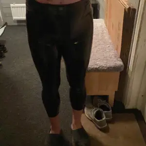 Säljer ett par svarta glansiga leggings i lackleggings. De är tighta och har en hög midja som ger en snygg siluett. Perfekta för en utekväll eller fest! 🖤