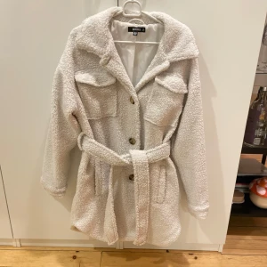 Teddyjacka från Nelly - Vit teddyjacka från Nelly. Band och knappar