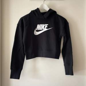 Cool och snygg svart hoodie från Nike. Superfint skick. Kort modell som passar bra till jeans i skolan eller på träningen. Väldigt lite använd. Storlek 137-146 cm. 