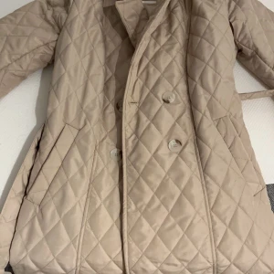 Beige jacka  - En väldigt fin jacka som är köpt utomlands. Jag har andra jackor och är inte i behov av denna jacka. Den är knappt använd men tvättas ändå innan den skickas iväg. Den är väldigt fin med ett skärp som du kan knyta eller spänna. Perfekt nu inför hösten