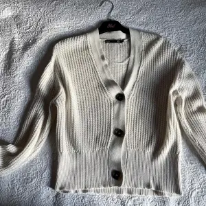 Vit cardigan från lager 157 den har använts några gånger men är fortfarande i bra skick. Den är lite stor i storleken så om du inte vill ha en lite oversized cardigan så är det rekommenderat att du köper om du har S eller M som storlek.