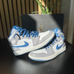 Jordan 1 true blue - Säljer ett par snygga Nike Air Jordan sneakers i grått och blått.  De är i bra skick skulle säga 8/10 storlek 40