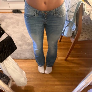 Ljusblå jeans med hjärtdetaljer - Säljer ett par ljusblå low bootcut jeans. De har snygga hjärtbroderier på bakfickorna i gul tråd som ger en unik touch. Jeansen är lågmidjade och har en klassisk femficksdesign. Perfekta för en casual look! storlek 152 men passar xxs. Jag är 157cm