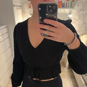 Blus - En jättefin svart blus från Bik bok. Den drar in lite i midjan med den rosett man knyter och den är V ringad. Super fin💗
