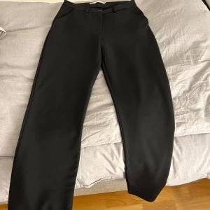 Svarta kostymbyxor - Svarta kostymbyxor som är kortmidjade. Använda ett få tal gånger och är i mycket god skick. Storleken är XS.