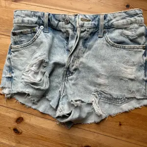 Säljer ett par ljusa jeansshorts från HM &Denim i storlek M. Passar mig som brukar ha xs/s. De är midwaist skulle jag säga. Cool, sliten look med revor. Perfekta för sommaren och ger en avslappnad stil. Passar både till stranden och en dag på stan!