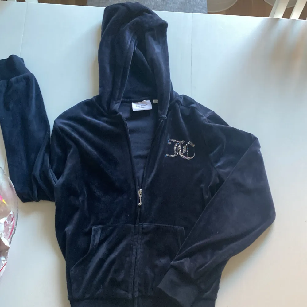 Sparsamt använt Juicy Couture set. Mörkblå med stenar (alla kvar). Fickor utan text bak på byxor. Jacka strl 10/11 (år). Byxor strl 9/10 (år). Fler bilder kan skickas vid intresse.. Sportswear.