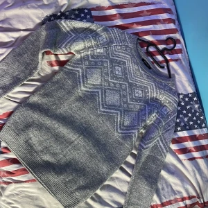 Grå stickad tröja från Esmara - Säljer en supermysig grå stickad tröja från Esmara. Den har ett snyggt geometriskt mönster i vitt över bröstet och är perfekt för kyliga dagar. Tröjan är långärmad och är i storlek XS men passar S också. Perfekt för höst och vinter.