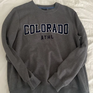 Vintage Tjocktröja Colorado - Storlek: L Använt sparsamt. Färg: Grå, mörkblå text.