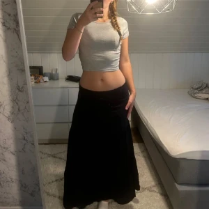 Svart långkjol i bomull - Säljer en superfin svart långkjol i bomull. Den har en elastisk midja som gör den bekväm och lätt att bära. Perfekt för både vardag och festliga tillfällen. Kjolen är i nyskick och redo för en ny ägare! jag är 177 till referens💗