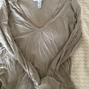 Beige långärmad tröja från Only Trend - Säljer en stilren beige långärmad tröja från nelly Trend. Den har en v-ringad hals och är perfekt för en avslappnad vardagslook. Tröjan är i storlek S . Perfekt för höst och vår!