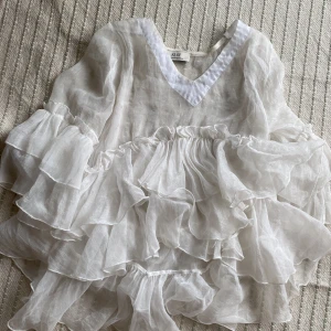 Vit volangklänning från Me369 - Säljer en superfin vit långärmad tröja från Ke.ke. Den har en luftig och romantisk stil med flera lager av volanger. tröjan är långärmad och har en v-ringad hals. Perfekt för sommarens fester eller en dag på stan. Materialet känns lätt och bekvämt att bära. 