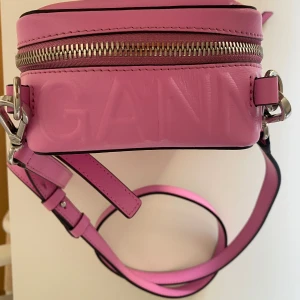 Ganni  - GANNI  Väska Crossbody bag ( juster samt avtagbart bälte) fick på insidan. Strl: H 17,5 L 12,5 cm. Material: 100% återvunnet läder. (Insidan 100% återvunnen bomull).  Skick: Använd ett fåtal gånger. Väldigt fint skick. Lite skråma se inringning 