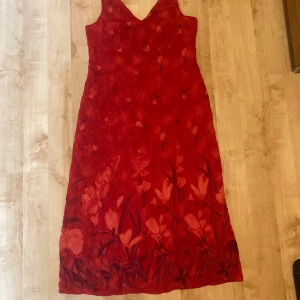 Cappuccini by Desam långklänning - Superfin röd långklänning med blommönster från Cappuccini. Storlek 42, passar L-XL