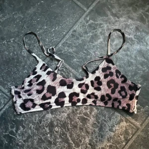 Leopardmönstrad bikiniöverdel - Säljer en supercool leopardmönstrad bikiniöverdel. Den har smala axelband och en enkel design som passar perfekt för en dag på stranden eller vid poolen. Materialet känns mjukt och bekvämt mot huden. Perfekt för dig som vill sticka ut i sommar!