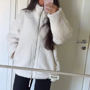 Vit teddyjacka  H&M - Mysig vit teddyjacka med dragkedja framtill. Jackan har en hög krage och två stora fickor. Perfekt för kyliga dagar när du vill hålla dig varm och bekväm. Slutsåld på H&M . Använd fåtal ggr ser ut som ny