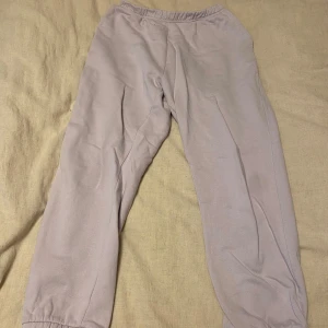 Ljuslila mjukisbyxor - Säljer ett par bekväma beige mjukisbyxor i storlek L. Perfekta för en avslappnad dag hemma eller en snabb tur till affären. Byxorna har en elastisk midja för extra komfort. De är i bra skick och redo för en ny ägare!